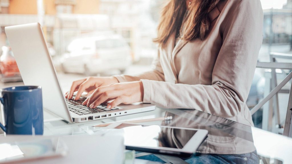 A woman sitting at a table using a laptop computer