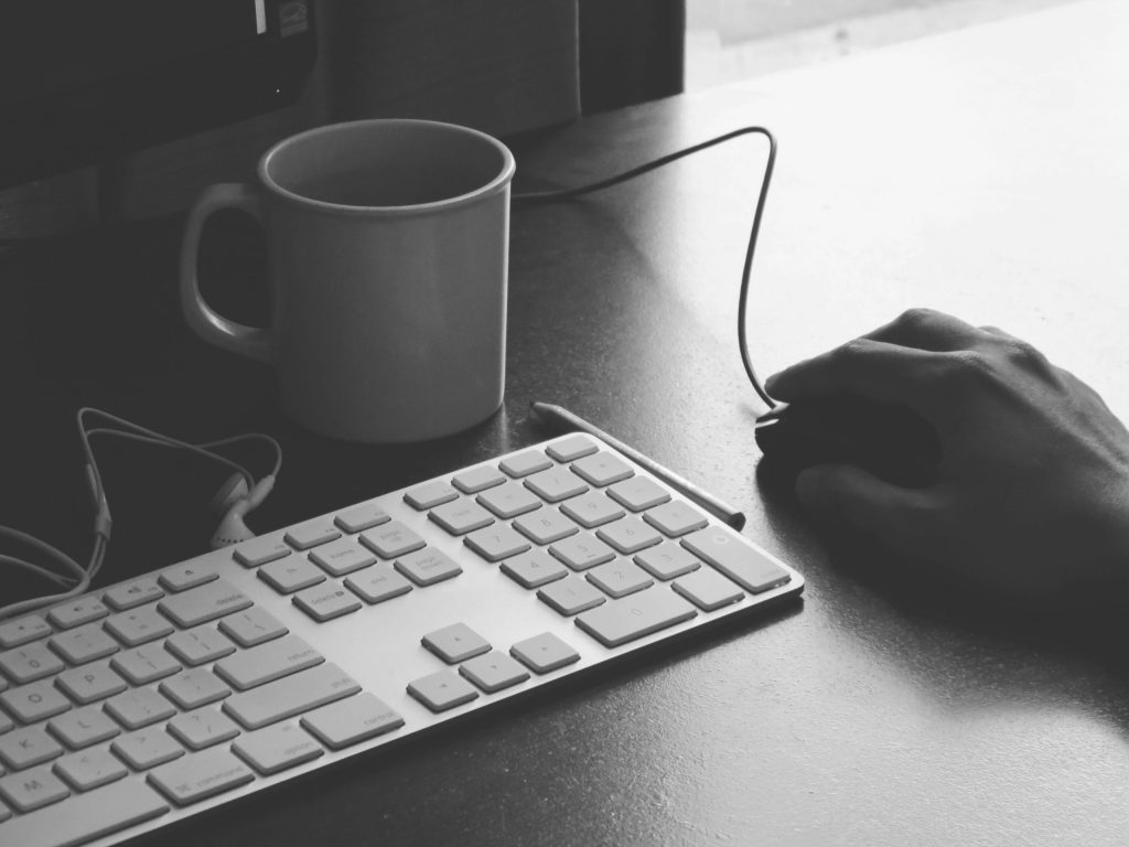 A computer keyboard and mouse on a desk